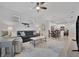 Spacious living room with gray sofa and views to kitchen and dining area at 10358 Abaco Falls Dr, Englewood, FL 34223