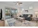 Living room with gray sofa, access to pool area, and rug at 10358 Abaco Falls Dr, Englewood, FL 34223