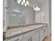 Double vanity bathroom with granite countertop and modern fixtures at 10426 Abaco Falls Dr, Englewood, FL 34223
