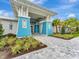 Side view of Beachwalk community clubhouse showcasing landscaping and blue exterior at 10426 Abaco Falls Dr, Englewood, FL 34223