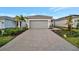 Single-Gathering home with gray garage door and paver driveway at 10426 Abaco Falls Dr, Englewood, FL 34223
