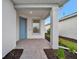 Quaint front porch with blue door and brick pavers at 10426 Abaco Falls Dr, Englewood, FL 34223