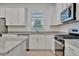 White shaker cabinets, granite countertops, and stainless steel appliances at 10426 Abaco Falls Dr, Englewood, FL 34223