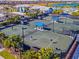 Beachwalk tennis courts with people playing and blue shade structures at 10426 Abaco Falls Dr, Englewood, FL 34223