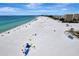 Expansive aerial view of beach with people at 1200 E Peppertree Ln # 307, Sarasota, FL 34242