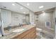 Bathroom features a granite countertop vanity, large mirror, and tiled shower with glass door at 1200 E Peppertree Ln # 307, Sarasota, FL 34242