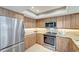 Well-appointed kitchen with stainless steel appliances, granite countertops, and warm wood cabinetry at 1200 E Peppertree Ln # 307, Sarasota, FL 34242