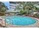Inviting community pool with surrounding lounge chairs at 1200 E Peppertree Ln # 307, Sarasota, FL 34242