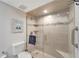 Tiled walk-in shower with glass door and built-in shelving in a modern bathroom at 1200 E Peppertree Ln # 307, Sarasota, FL 34242