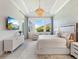 Luxurious main bedroom with large windows, a sitting area, and neutral decor at 19405 Ganton Ave, Lakewood Ranch, FL 34202