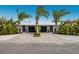 A home's exterior showcases a modern design with a metal roof and lush landscaping at 213 83Rd St # West, Holmes Beach, FL 34217