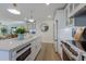 Modern kitchen with white cabinets, quartz countertops, and stainless steel appliances at 213 83Rd St # West, Holmes Beach, FL 34217