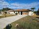 Single-story house with a driveway, landscaping, and two palm trees at 25484 Terrain Ln, Punta Gorda, FL 33983