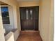 Dark brown front door with glass panels and brick flooring at 25484 Terrain Ln, Punta Gorda, FL 33983
