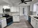 Modern kitchen with white cabinets, granite countertops, and teal appliances at 25484 Terrain Ln, Punta Gorda, FL 33983