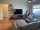 Relaxing living room featuring sectional sofa, TV, and wood-look floors at 323 Mira Vista Dr, Dunedin, FL 34698