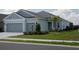 Two-story house with gray siding, two-car garage, and landscaped yard at 4406 Rustling Pines Ter, Parrish, FL 34219