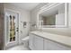 Modern bathroom with white cabinets, a large mirror, and an exterior door at 4611 Shark Dr, Bradenton, FL 34208