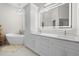Modern bathroom with double vanity, large mirror, and bathtub at 4611 Shark Dr, Bradenton, FL 34208