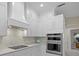 Modern kitchen with white cabinets, marble backsplash and double oven at 4611 Shark Dr, Bradenton, FL 34208
