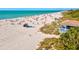 Expansive view of a crowded sandy beach where sunbathers, swimmers, and other vacationers enjoy the sun at 482 Rubens Dr E, Nokomis, FL 34275