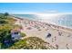 Expansive view of a crowded sandy beach where sunbathers, swimmers, and other vacationers enjoy the sun at 482 Rubens Dr E, Nokomis, FL 34275