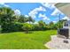 A well-maintained backyard features lush greenery and privacy hedging at 482 Rubens Dr E, Nokomis, FL 34275