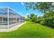 The spacious backyard features a screened-in pool area and lush landscaping for privacy at 482 Rubens Dr E, Nokomis, FL 34275