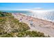 Aerial view of a sunny beach with people enjoying the ocean and sand at 482 Rubens Dr E, Nokomis, FL 34275
