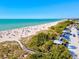 Beautiful ocean view of a sandy beach with clear turquoise water and palm trees at 482 Rubens Dr E, Nokomis, FL 34275