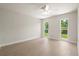 Spacious bedroom with wood-look flooring, ceiling fan, and view to the backyard at 482 Rubens Dr E, Nokomis, FL 34275