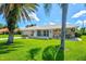 Beautiful single-story home features a well-manicured lawn, stone accents, and lush palm trees at 482 Rubens Dr E, Nokomis, FL 34275
