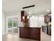 Modern kitchen features a breakfast bar with pendant lighting and stainless steel appliances, connecting seamlessly to the outdoor pool area at 482 Rubens Dr E, Nokomis, FL 34275