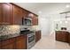 Modern kitchen with stainless steel appliances, dark wood cabinets, and a view into living area at 482 Rubens Dr E, Nokomis, FL 34275