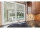 Close-up of modern kitchen with granite counters, dark wood cabinets, and a view of the pool at 482 Rubens Dr E, Nokomis, FL 34275