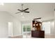 Bright living room provides access to a modern kitchen and screened-in pool via sliding glass doors, enhanced by a ceiling fan at 482 Rubens Dr E, Nokomis, FL 34275