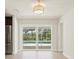 Bright living room featuring sliding glass doors leading to a pool and a modern light fixture at 482 Rubens Dr E, Nokomis, FL 34275