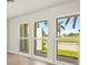 Bright living room with new floors, fresh paint, and large windows with a view of the palm trees at 482 Rubens Dr E, Nokomis, FL 34275