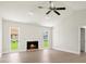Bright living room boasts a cozy fireplace, vaulted ceilings, and dual windows offering views of the landscaped backyard at 482 Rubens Dr E, Nokomis, FL 34275