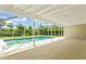 A screened-in pool area featuring a tiled deck and a clear view of the lush backyard landscaping at 482 Rubens Dr E, Nokomis, FL 34275