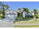 Charming single-story home featuring a well-manicured lawn, a two-car garage, and tropical landscaping at 5307 52Nd W Ave, Bradenton, FL 34210