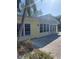 Bright yellow house with multiple windows and a patio at 563 Juan Anasco Dr, Longboat Key, FL 34228