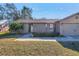 Tan house with a two-car garage and well-maintained lawn at 6025 62Nd E Ct, Palmetto, FL 34221