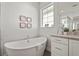 Elegant bathroom features a soaking tub with a view, a glass shower and modern fixtures, plus neutral toned tile at 8328 Sea Glass Ct, Sarasota, FL 34240