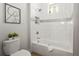 Bathroom features a bathtub and shower with white subway tile and stylish black and white art at 8328 Sea Glass Ct, Sarasota, FL 34240