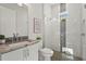 This bathroom includes an elegant granite countertop, shower with neutral tile, and a window for natural light at 8328 Sea Glass Ct, Sarasota, FL 34240