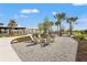 Community space with lounge seating surrounded by mature palm trees and lush landscaping at 8328 Sea Glass Ct, Sarasota, FL 34240