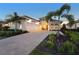 Well-lit single-Gathering home with a paved driveway, lush landscaping, and a two-car garage at dusk at 8328 Sea Glass Ct, Sarasota, FL 34240