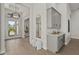 Bright foyer with a bar area, decorative mirror, tile floors, and a view of the front door at 8328 Sea Glass Ct, Sarasota, FL 34240