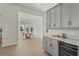 Modern kitchen with light wood floors, gray cabinets, and a wine cooler, creating a stylish and functional space at 8328 Sea Glass Ct, Sarasota, FL 34240